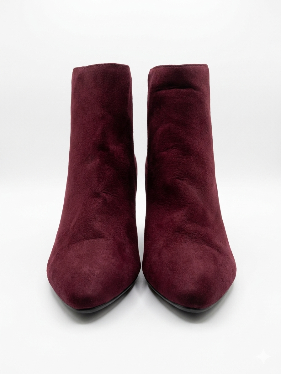 Pair of burgundy suede ankle boots on a white background